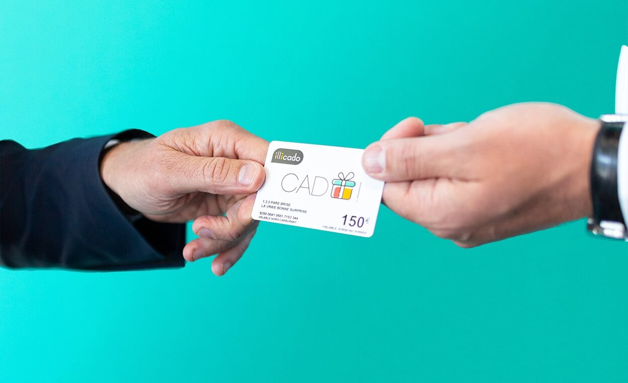 mains tenant une carte cadeau Illicado de 150€