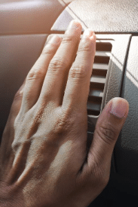 Main devant la climatisation d'une voiture