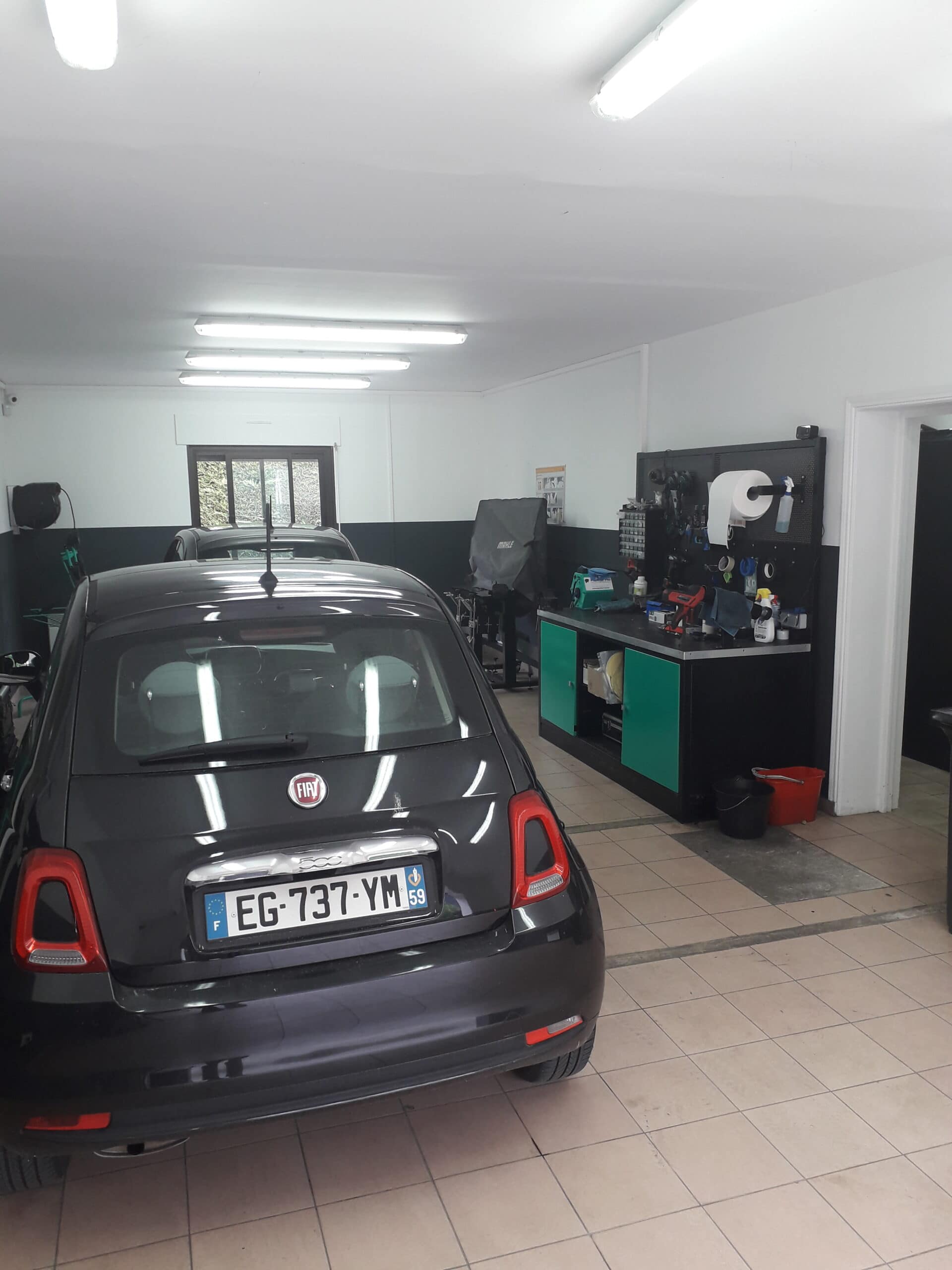 Atelier de l'agence 123 Pare-Brise Boulogne-sur-Mer avec une Fiat 500 à l'intérieur