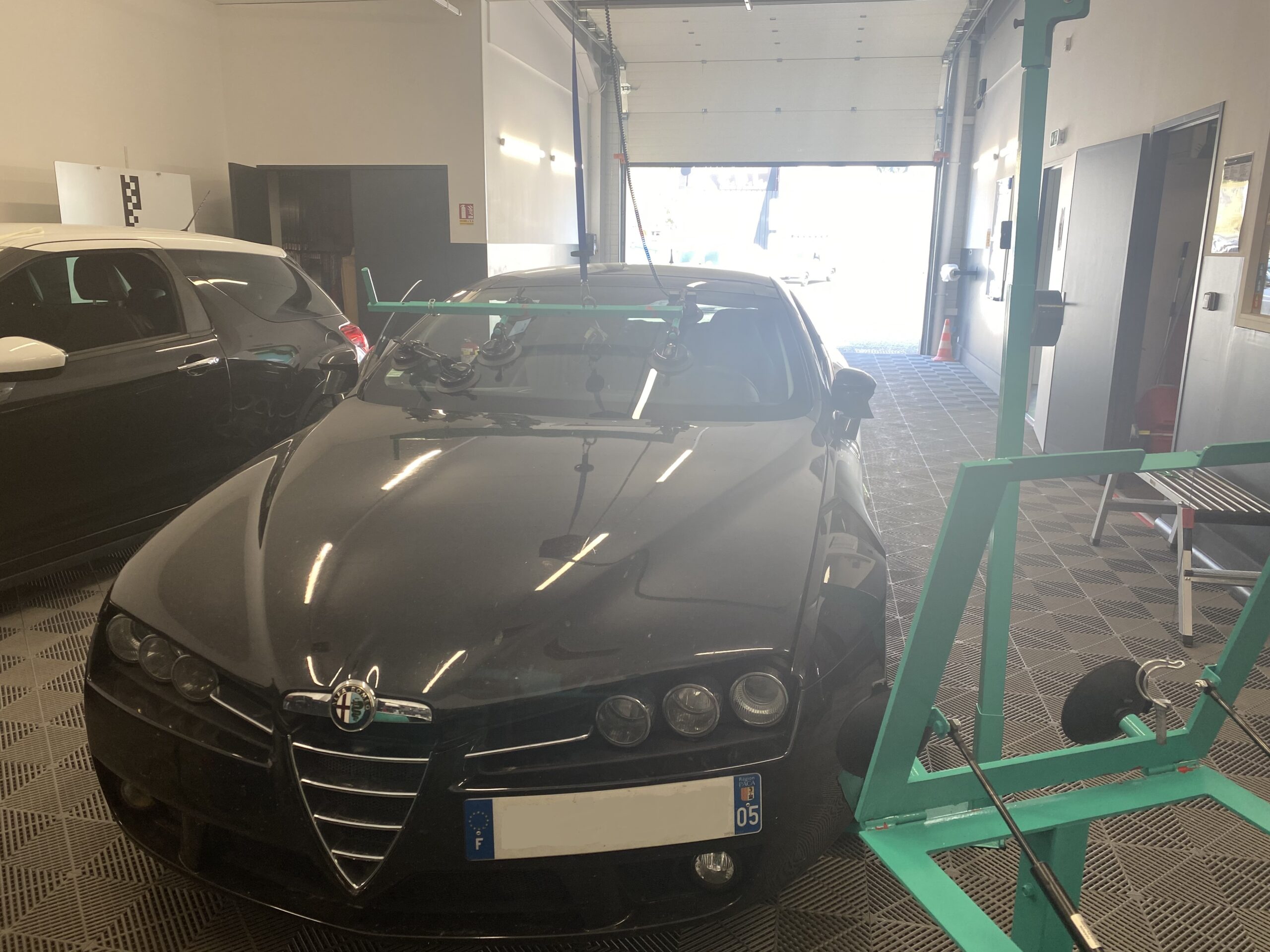 Intervention de remplacement de pare-brise sur une Alpha Roméo dans l'atelier 123 Pare-Brise Chambéry