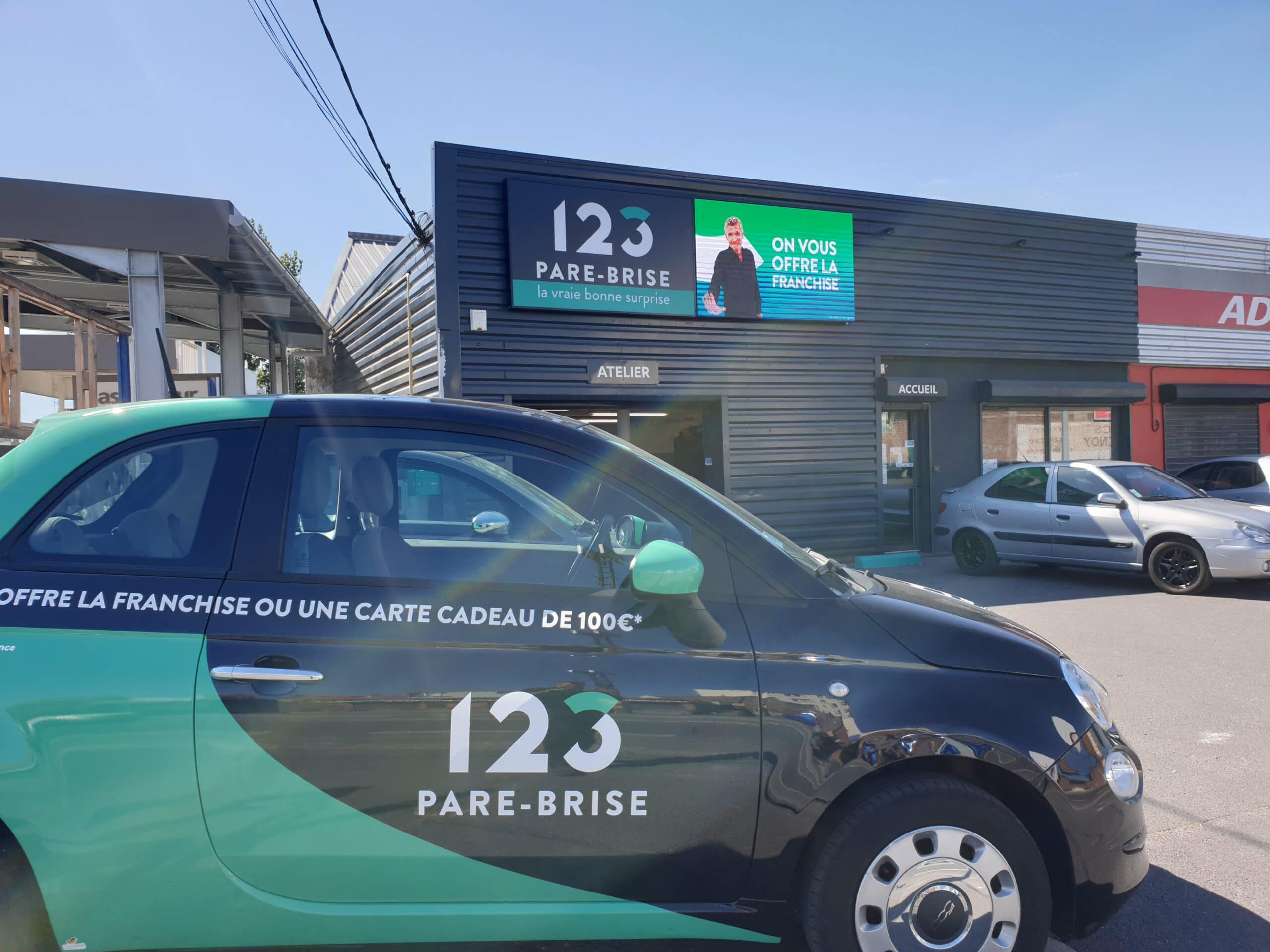 Véhicule de courtoisie de profil devant le centre 123 Pare-Brise Lens