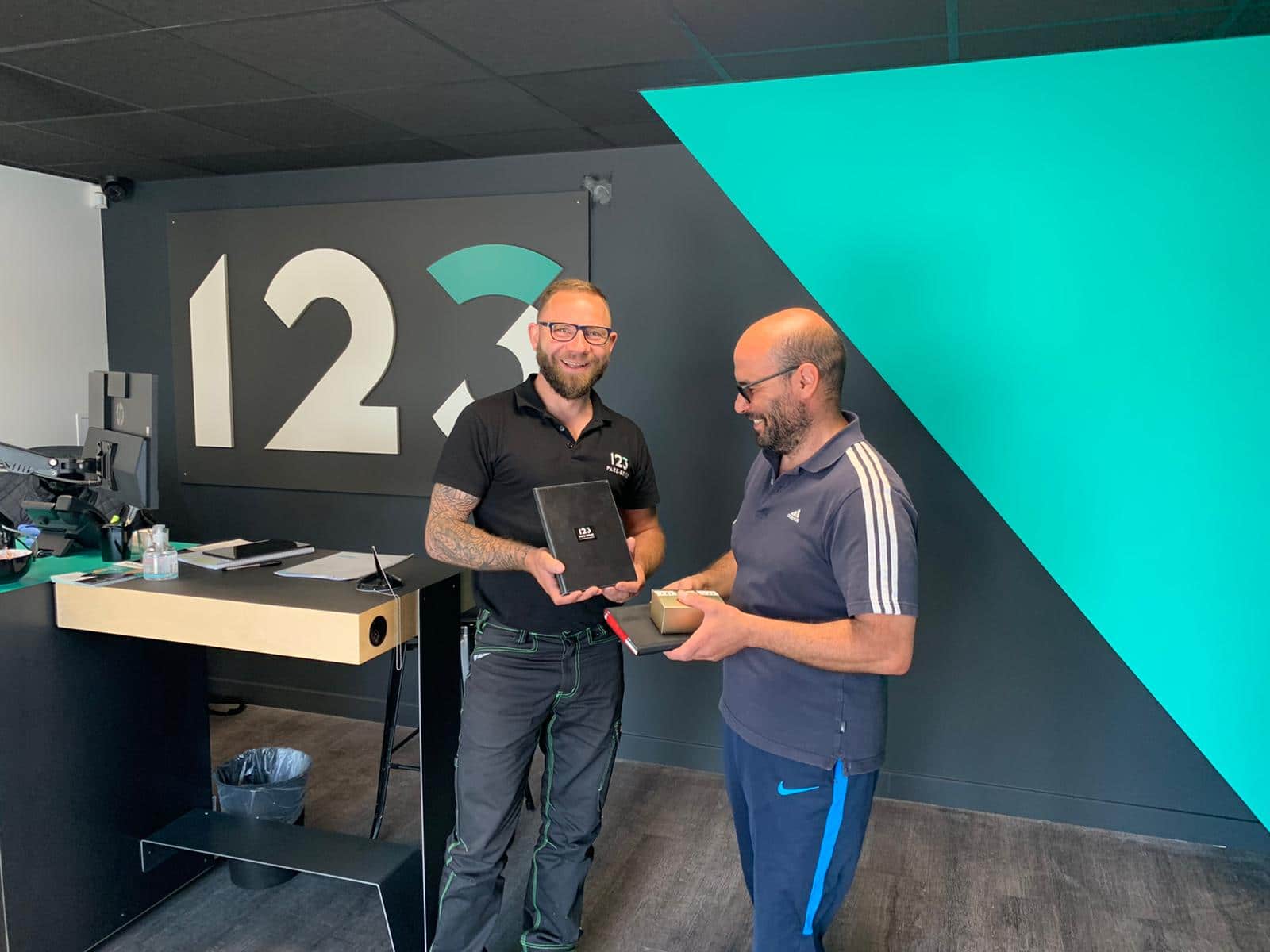 Remise d'une pochette 123 Pare-Brise à un client satisfait