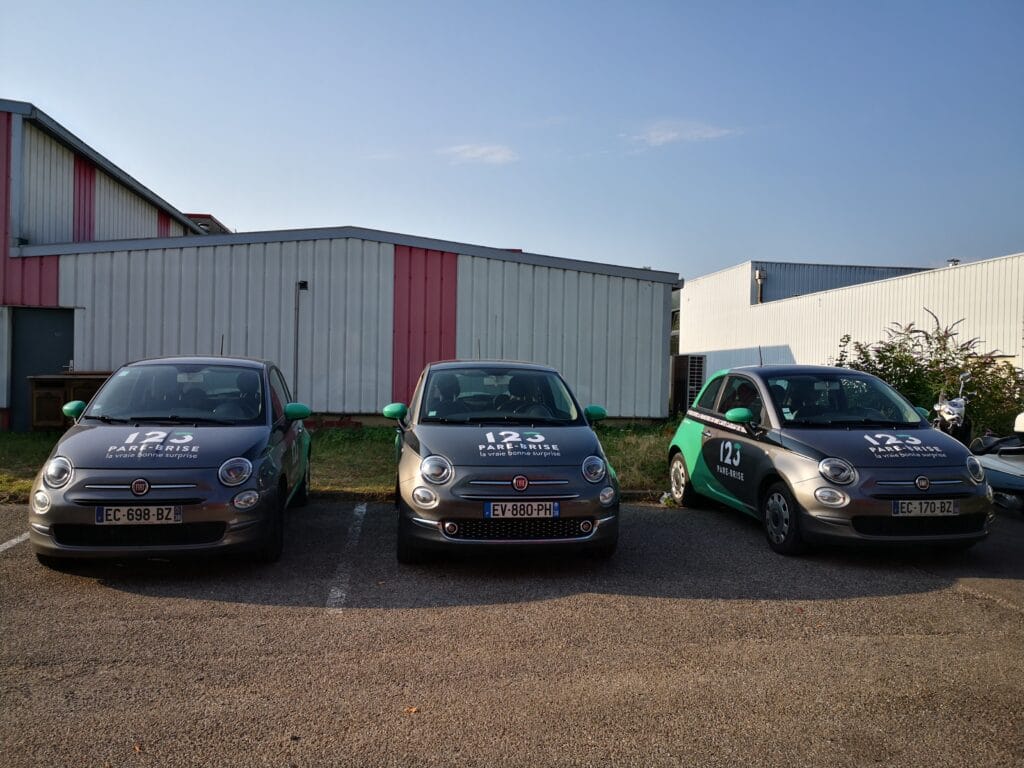 123PareBrise-echirolles-vehicule-de-pret Trois véhicules de prêt floqué 123 Pare-Brise sur le parking du centre d'Echirolles
