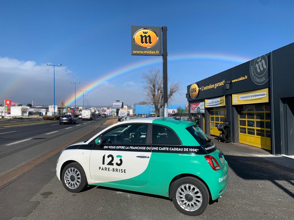 Véhicule de courtoisie de l'agence 123 Pare-Brise Aubière avec un arc-en-ciel